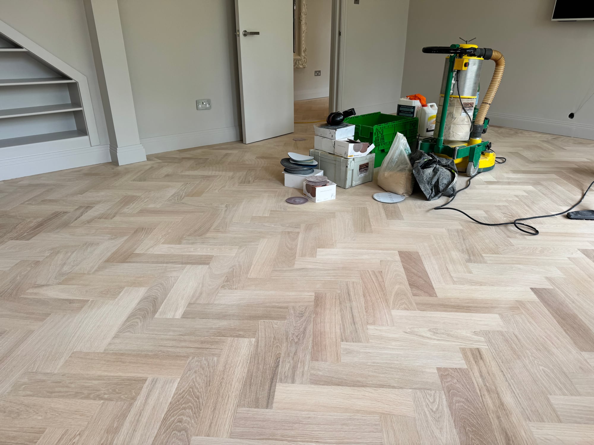 Light herringbone parquet during sanding