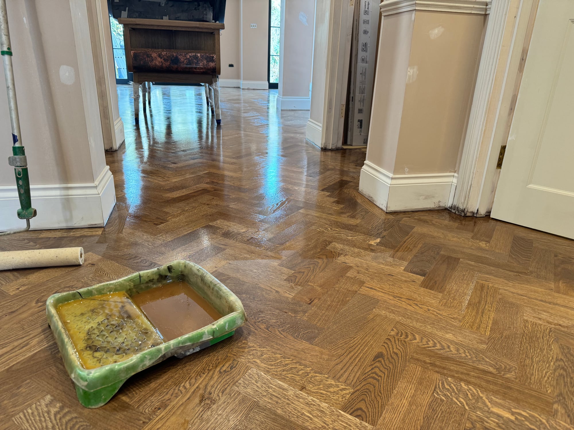 Freshly refinished herringbone parquet floor catching the light