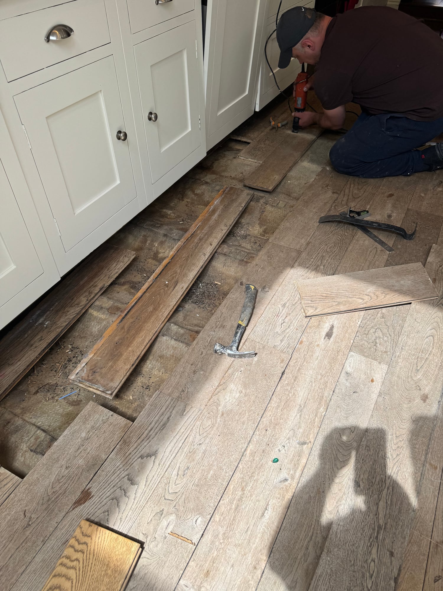 Hands-on board repair and gap filling on a reclaimed oak floor