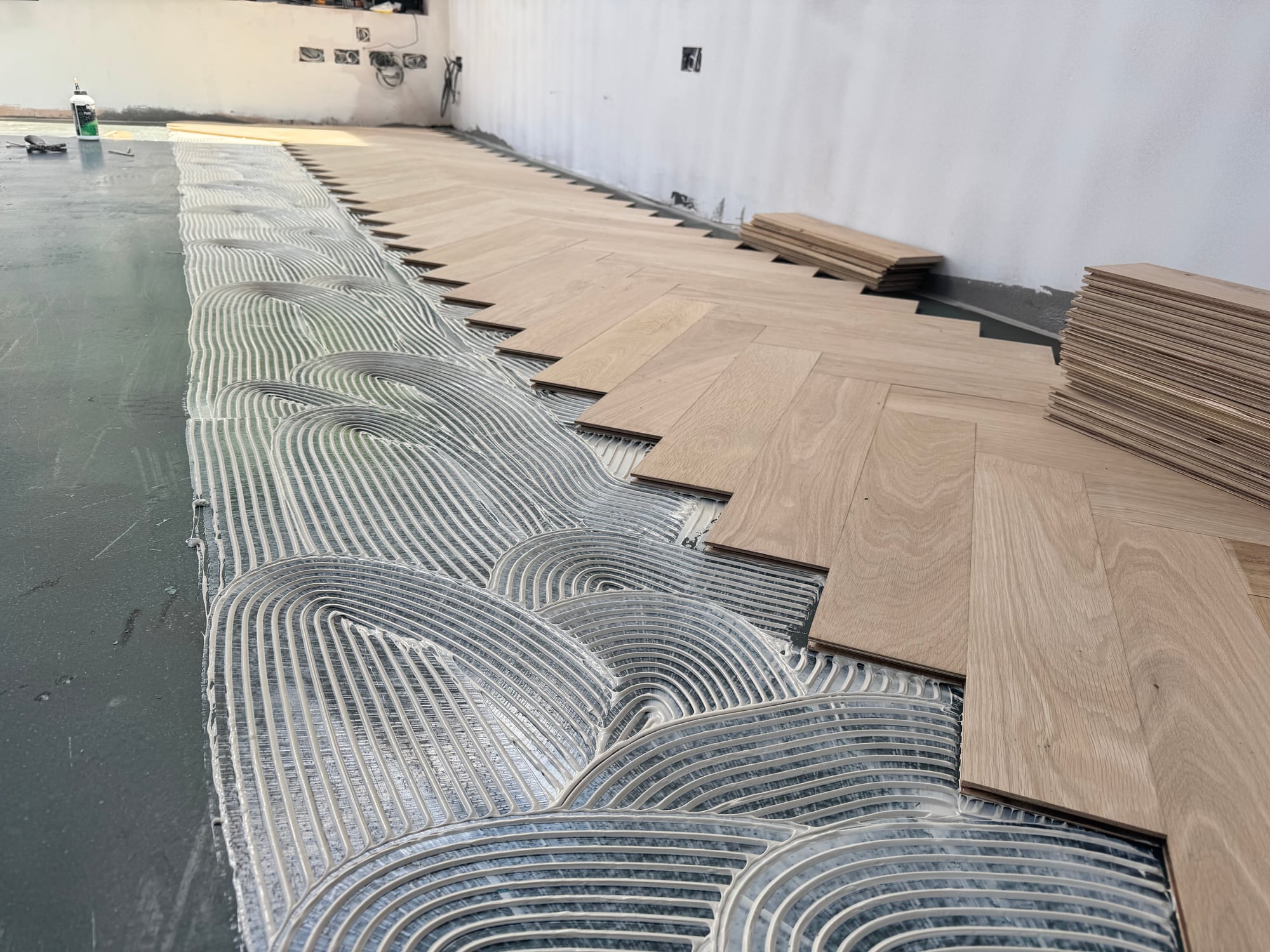 Parquet boards being glued over underfloor heating