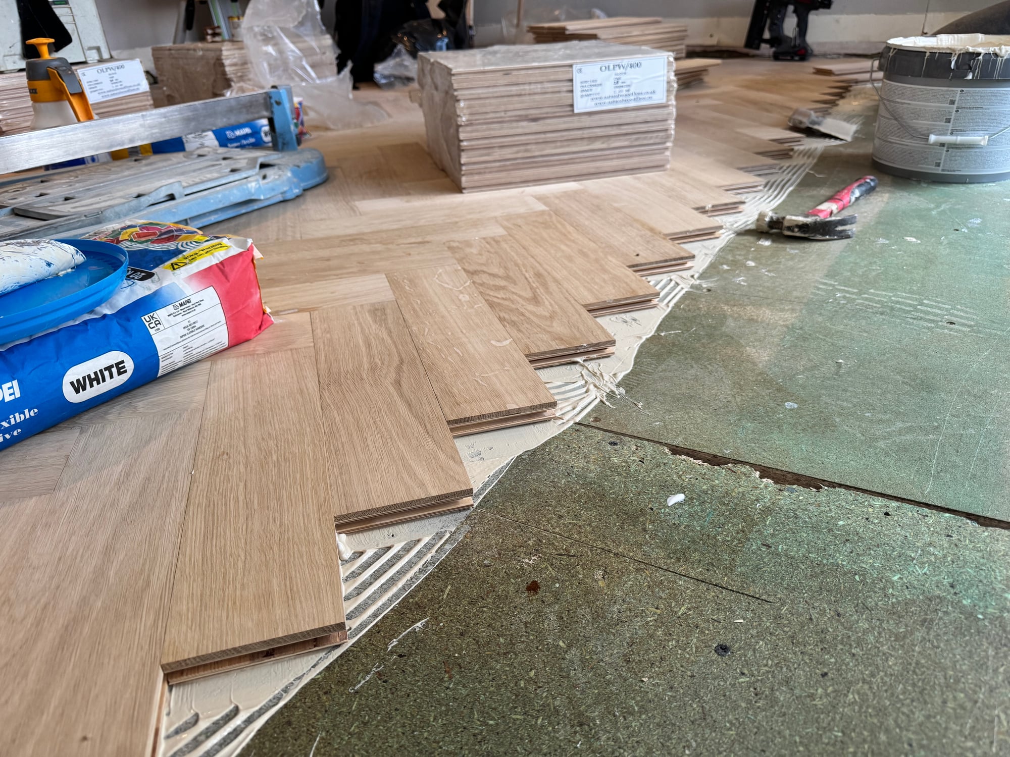 Herringbone parquet boards mid-install